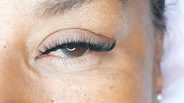 Close up of eye with eyelash Extensions in beauty salon, lash treatment