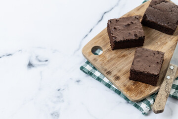 Chocolate brownie portions on marble background. Copy space