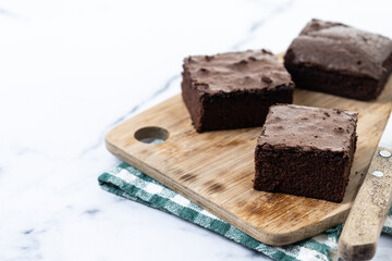 Chocolate brownie portions on marble background. Copy space