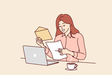 Happy woman freelancer opens envelope with letter standing near table with laptop and cup of coffee. Freelancer girl reads contract to perform work commissioned by commercial company.