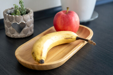 Banana and apple on the kitchen table.