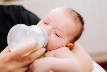 portrait of a newborn drinking from a feeding bottle