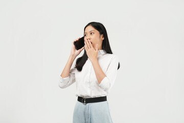 Portrait of a young Asian woman of shocked screaming holding phone in hand isolated on white background.