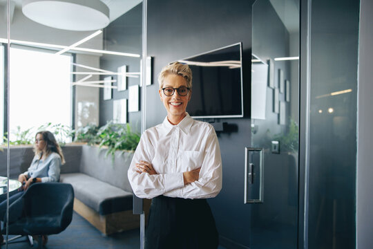Portrait of a mature business woman standing outside a meeting in a business office