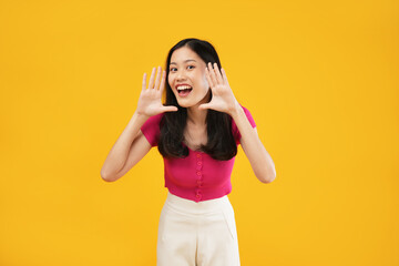 Obraz na płótnie Canvas Photo of a surprised young Asian woman looking excited holding her mouth open, hands on head. 