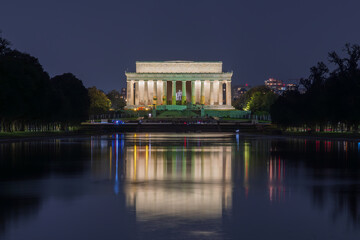 Fototapeta na wymiar Illuminated Lincoln Memorial at night reflecting in the Reflecting Pool in Washington DC, United States