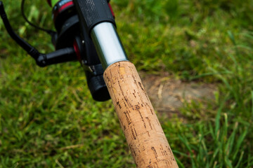 Fishing rod, spinning reel on the background of the pier on the river bank. Sunrise. Wild nature. Rural holiday concept. An article about a fishing day.