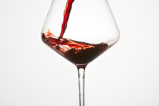 Red mature wine is poured into transparent glass.