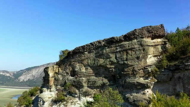 Aerial reveal footage of a stone cliff over the Studen kladenec dam, Rhodope mountain, Monyak peak, in Bulgaria