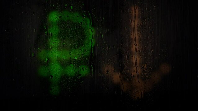 Russian rouble glowing sign with arrow down made from light bulbs. The symbol of the national currency behind a rain-wet window with water drops. Depreciation of the national currency