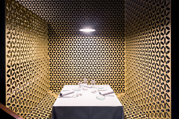 A white table sitting in a room restaurant with gold walls