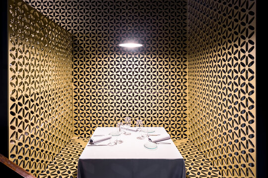A white table sitting in a room restaurant with gold walls