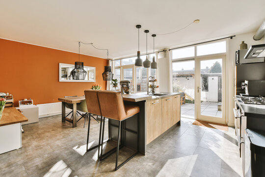 Kitchen with chairs by island against bright window