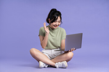 Portrait of beautiful asian woman posing on purple background