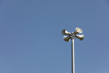 Whire horn speaker in the park with clear blue sky background..