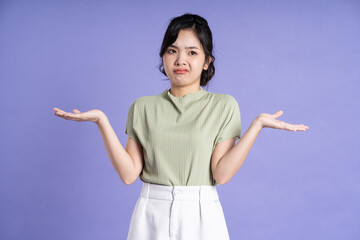 Portrait of beautiful Asian girl posing on purple background