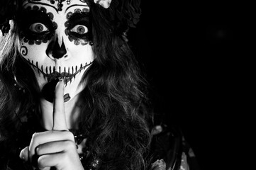 Woman in santa muerte makeup on a black background. Girl wearing traditional mexican holy death costume for halloween. Copy space