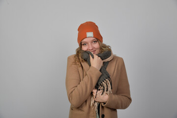 frau mit mütze schaal und mantel schal friert eingemummelt angezogen winterlich winter lachen...