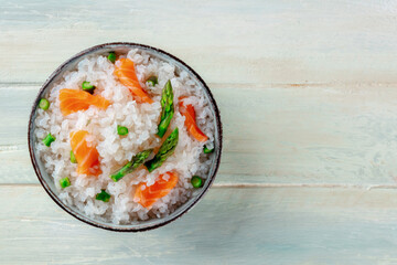 Konjac rice. Shirataki with salmon and asparagus, a healthy diet dish, overhead shot on a wooden background with copy space
