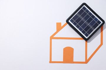 Solar panel and sketch of house on white background, space for text