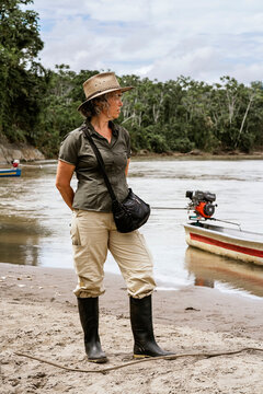 Mature traveler woman with bag on sandy shore