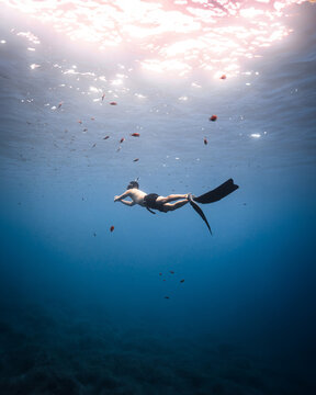 A man swimming in the ocean with a mask on