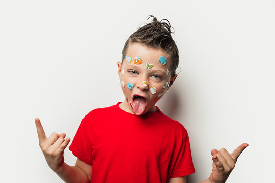 Boy with colorful stickers on his face and wet hair