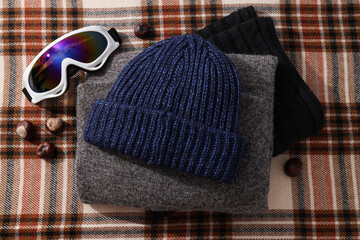 A warm knitted hat with ski goggles and a hood