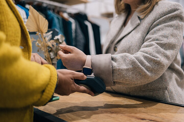 Close-up view of contactless transaction via smartwatch in boutique.