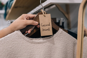 Sweater labeled as "Second hand" in a boutique setting.