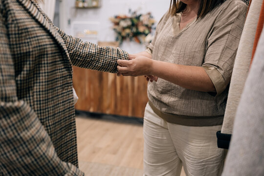 Unrecognizable woman Shopper inspecting houndstooth fabric in boutique.