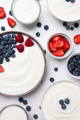 Bowls with yogurt and berries on white background, top view