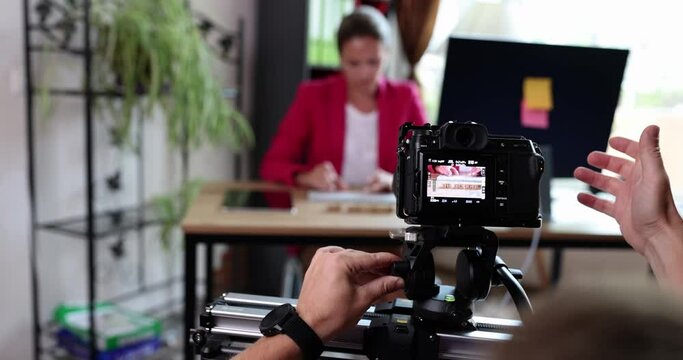 A digital camera takes a woman at a table in the office, close-up, shallow focus. Documentary Interview