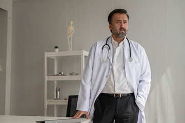 Portrait of professional doctor standing in uniform with stethoscope in hospital. confidence smart male doctor sitting in medical examination room.