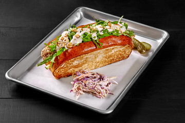 Sandwich in toasted brioche bread with chicken fingers, vegetables, mayo and cashews
