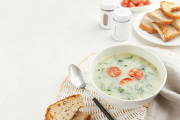 Typical Portuguese soup Caldo Verde with bread and chorizo sausage on gray background