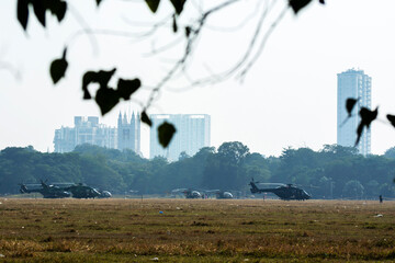 Military helicopter is ready to fly on a ground in a city.