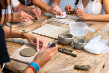 Fototapeta na wymiar Ceramic Workshop. Women working at a work table in the ceramic workshop.