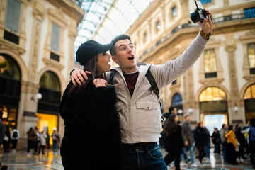 Fototapeten Couple of tourists taking selfies in Milan © Minerva Studio