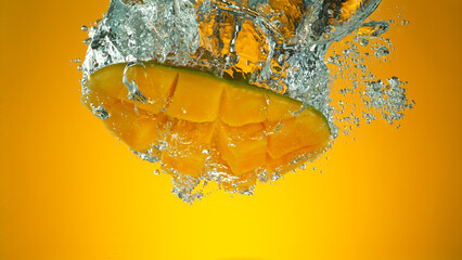 Freeze motion of falling fresh mango fruit into water