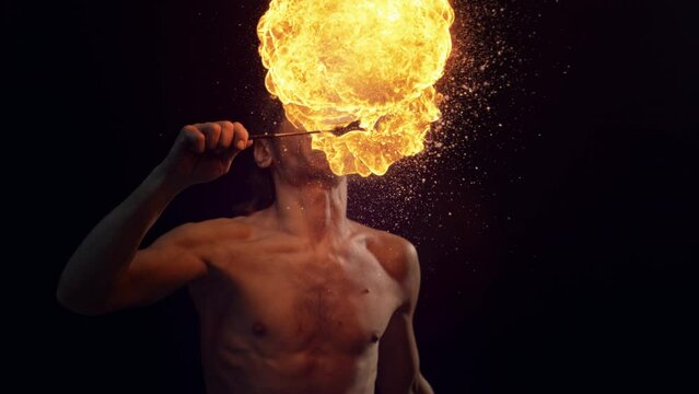 Fire Breather Performing at a Show on a Dark Stage. Male Performer Blowing Fire Out of His Mouth with a Striking Visual Effect. Cinematic Super Slow Motion Footage at 1000fps