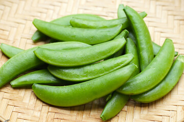 Fresh young green peas in bamboo weave plate