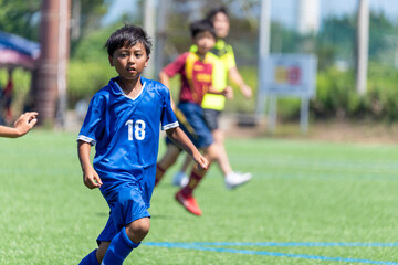サッカーの試合をする小学生の男の子