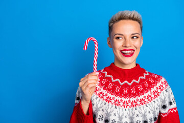Portrait of young positive christmas promoter girl wear red festive sweater look hungry lick teeth...