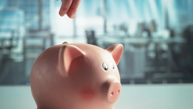 Close Up of an Anonymous Person's Hand Dropping an Euro Coin into a Cute Pink Piggy Bank. Financial and Business Safety Concept, Bank Savings and Investments Theme. Super Slow Motion Footage