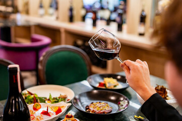 man hand holding a glass with red wine in a restaurant