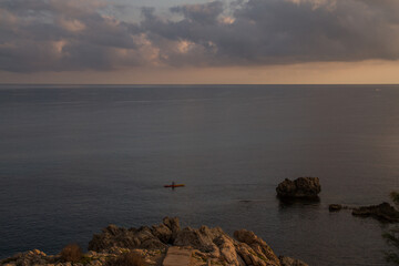 Isolated kayak in the sea at sunset, calm water, relaxing atmosphere, Mallorca island near Cala Ratjada, Mediterranean sea