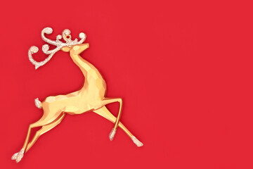 Christmas eve gold reindeer ornament on red background. Merry Christmas Noel Yule greeting card,...