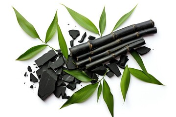 Top view of isolated activated charcoal with bamboo leaf on white background - obrazy, fototapety, plakaty