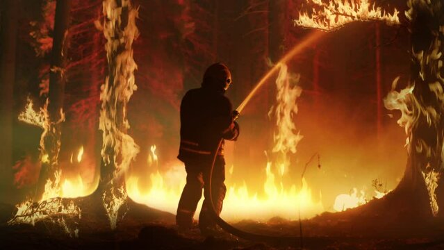 Professional Firefighters Extinguishing Large, High-Priority Part of the Forest Fire. Highly Skilled Hotshot Firemen Crew Working on Challenging Remote Area with Flames Reaching the Treetops